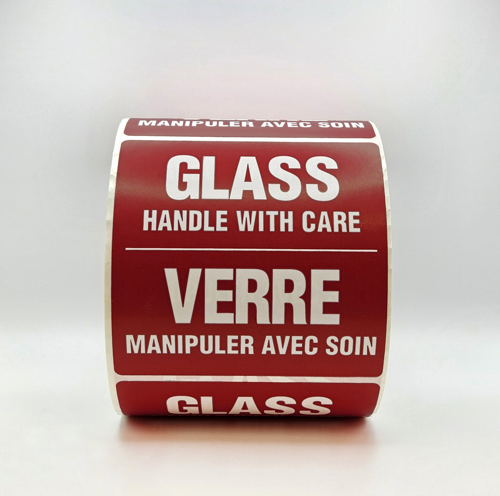 Roll of burgundy labels with white text warning 'Handle with care' on a white background