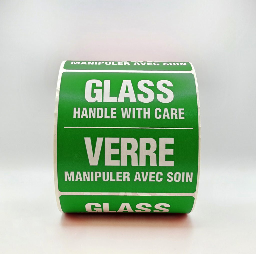 Roll of green labels with 'Glass Handle with Care' text on a white background