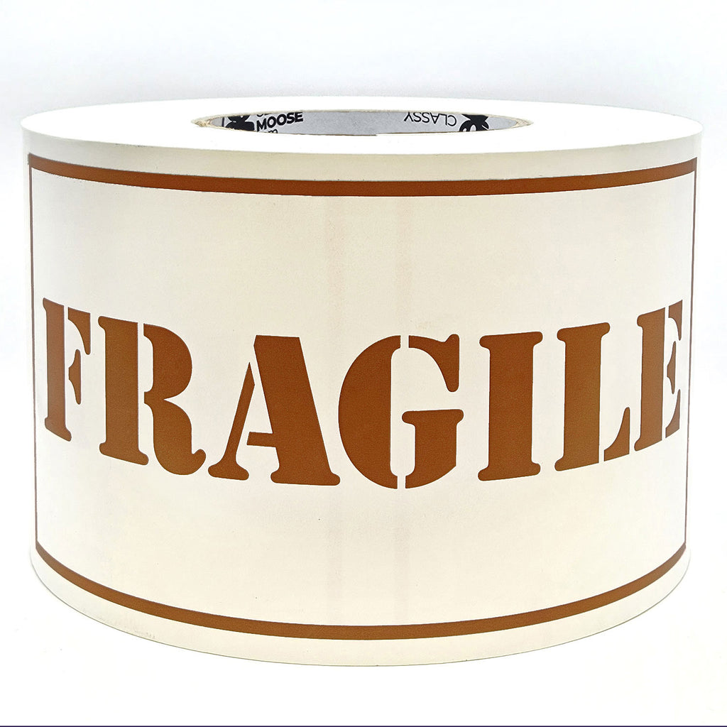 A roll of 'Fragile' sticker labels with the word 'Fragile' printed in brown on a white background with borders.
