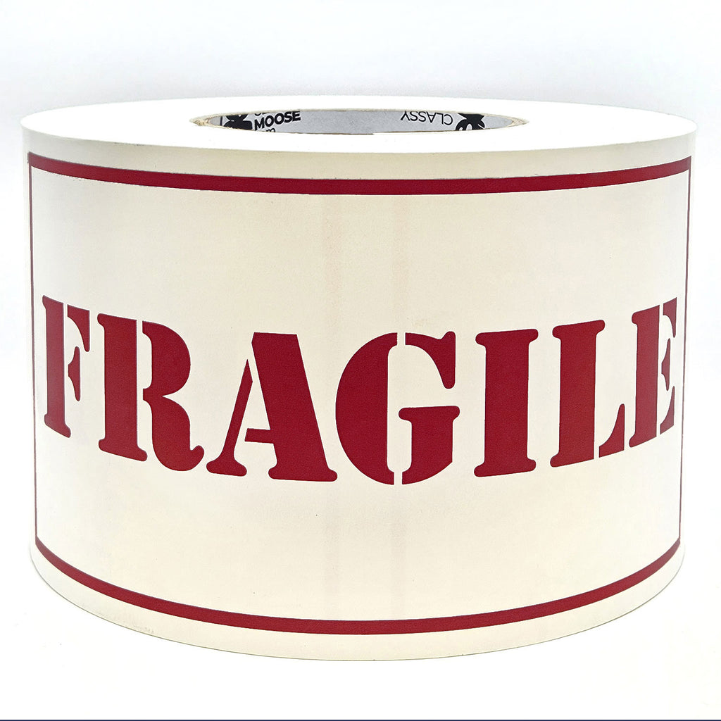 A roll of 'Fragile' sticker labels with the word 'Fragile' printed in burgundy on a white background with borders.