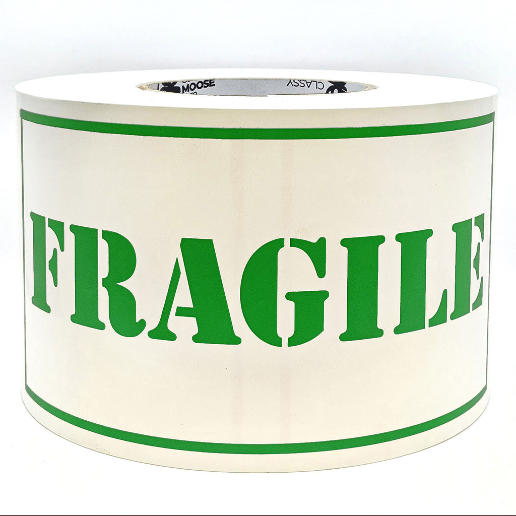 A roll of 'Fragile' sticker labels with the word 'Fragile' printed in green on a white background with borders.