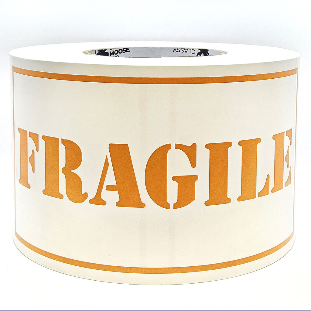A roll of 'Fragile' sticker labels with the word 'Fragile' printed in orange on a white background with borders.
