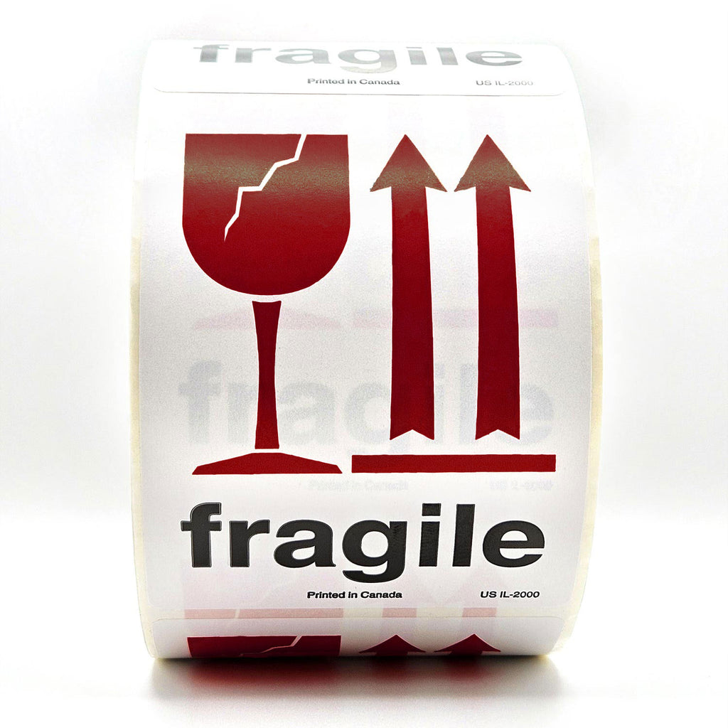 A roll of white shipping labels with 'Fragile' text and a burgundy broken glass symbol, and arrows pointing up on it. Front view