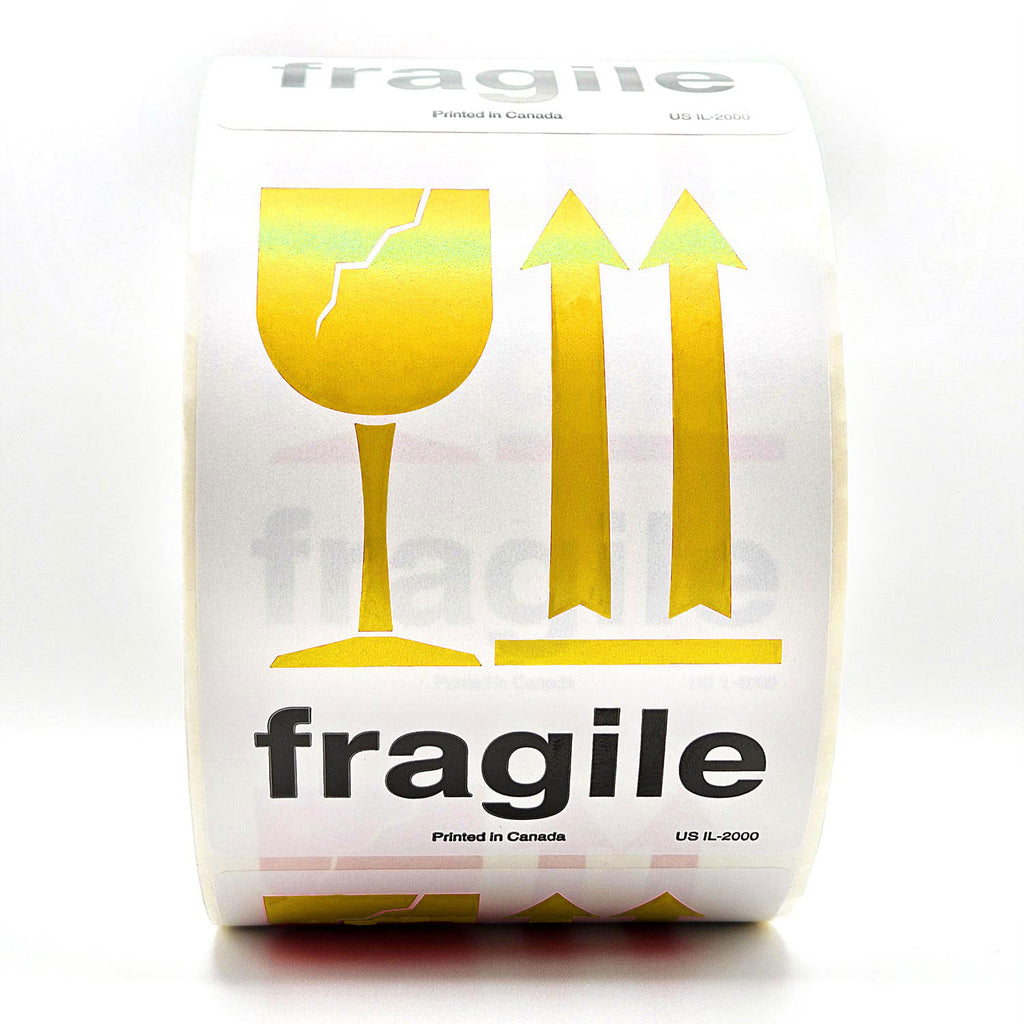 A roll of white shipping labels with 'Fragile' text and a yellow broken glass symbol, and  arrows pointing up on it. Front view
