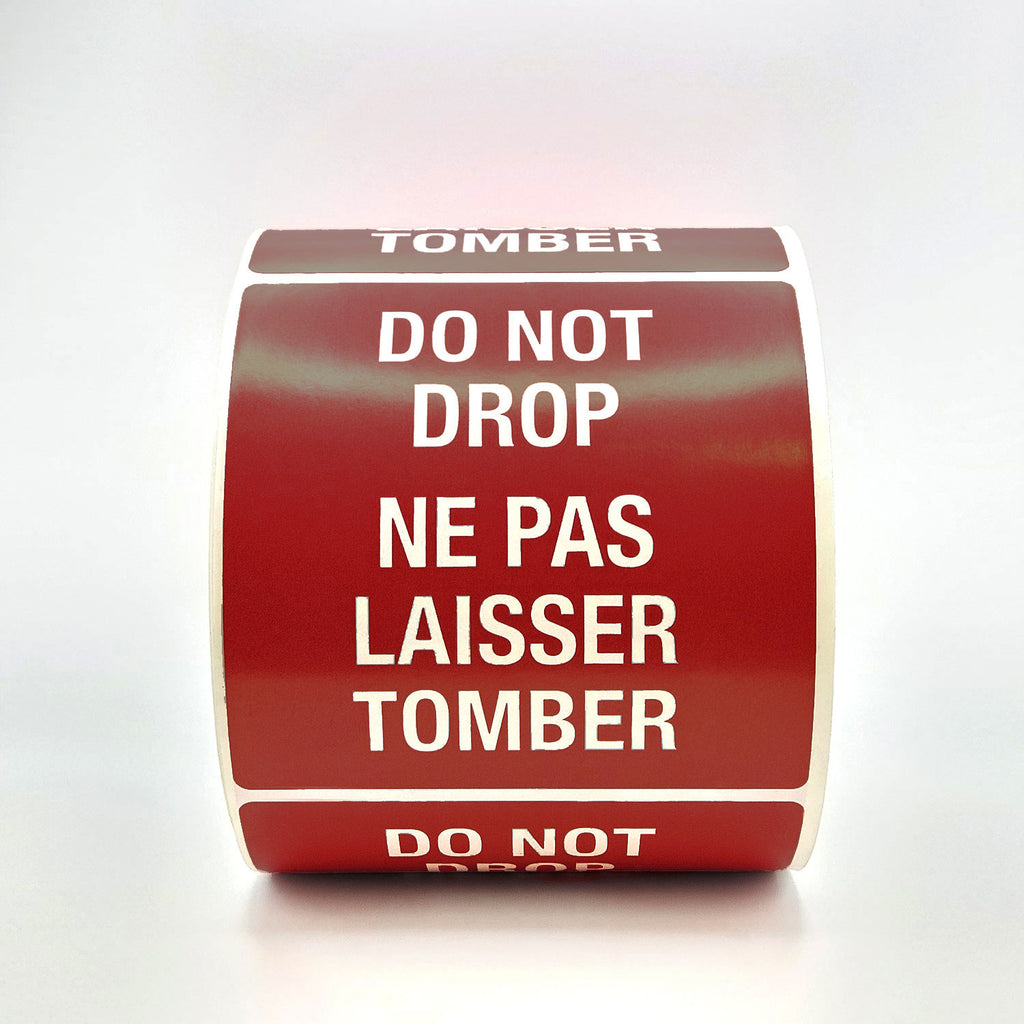 A roll of burgundy labels with 'DO NOT DROP' text in both English and French, indicating the labels are bilingual.