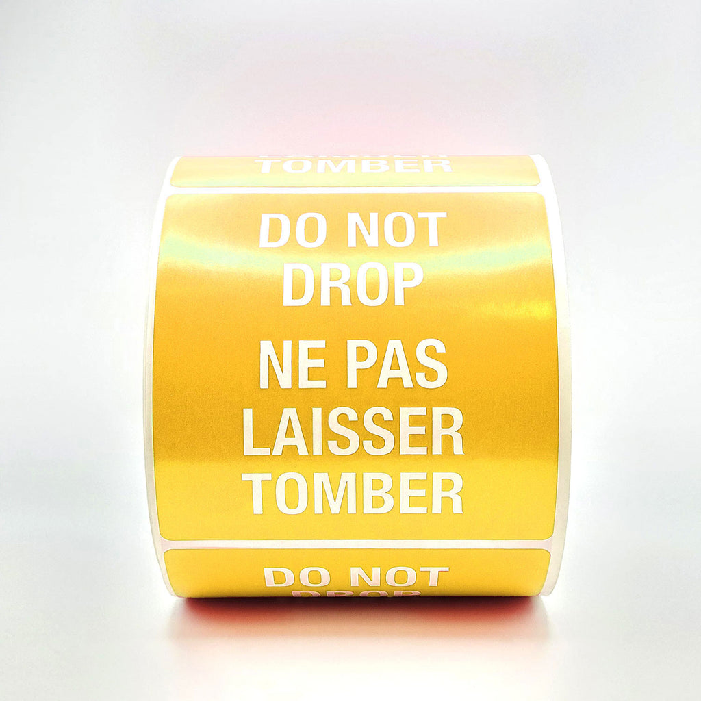 A roll of yellow labels with 'DO NOT DROP' text in both English and French, indicating the labels are bilingual.