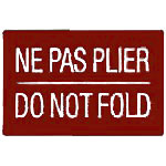 A burgundy label with white text that reads 'NE PAS PLIER DO NOT FOLD', indicating that items should not be folded.