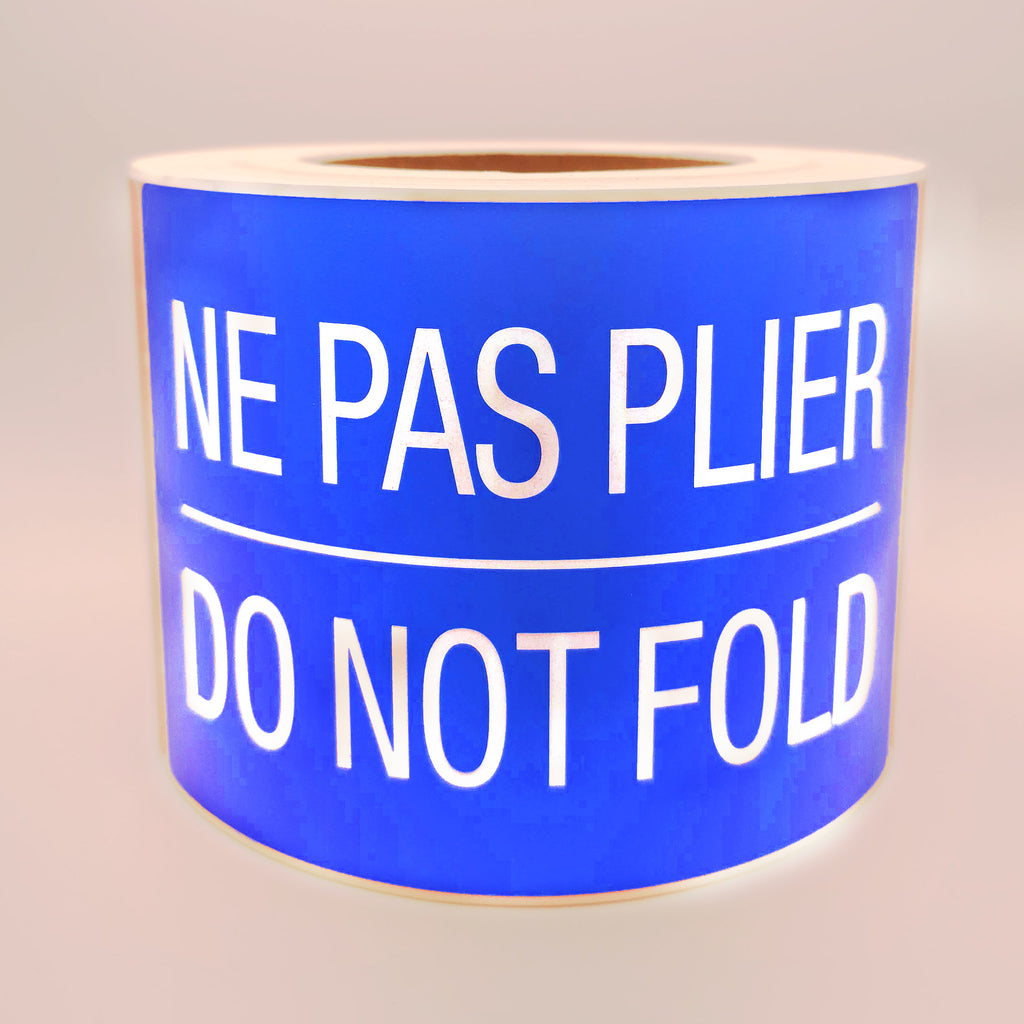 Roll of blue labels with white text 'NE PAS PLIER DO NOT FOLD' on a white background