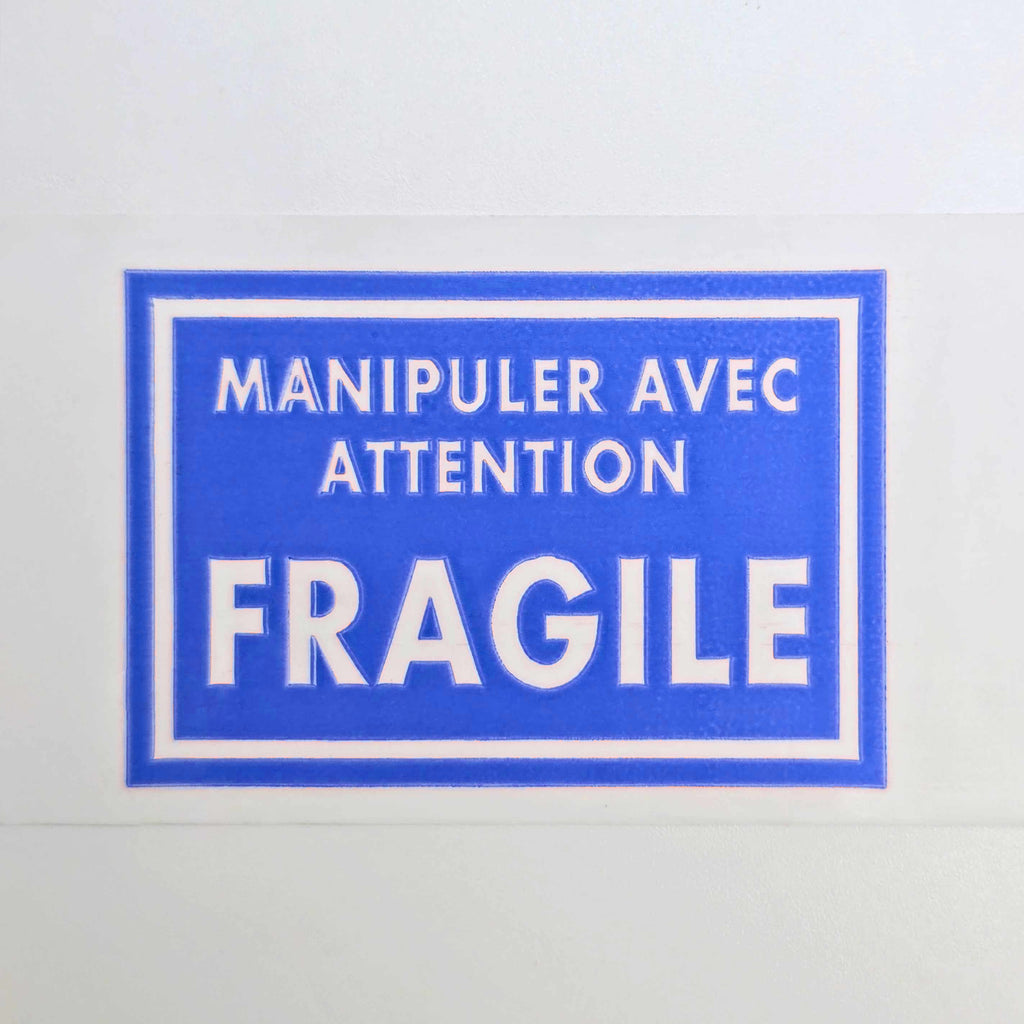 Blue fragile label with white text on a white background