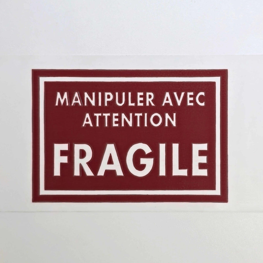 Fragile label with text 'Manipuler avec attention FRAGILE' on a white background