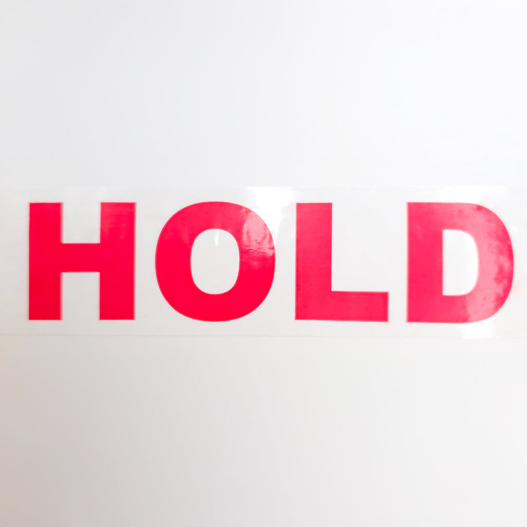Red 'HOLD' text on a white background